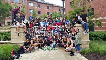 Large group of students sitting on steps on Rutgers campus in the summer.