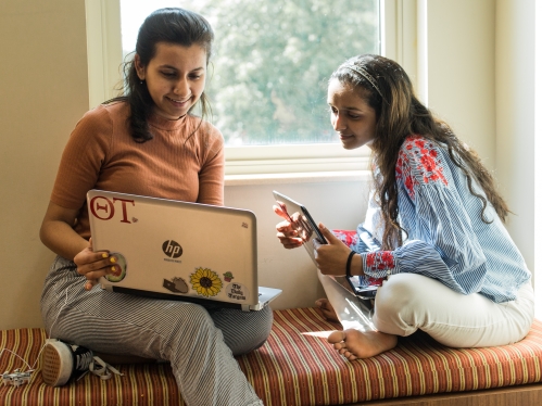 Two students sitting in dorm