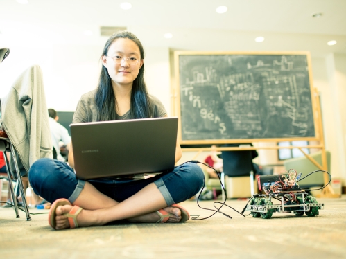 Student sitting crossed legged on floor.