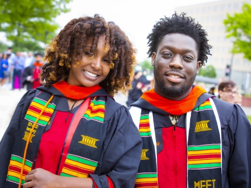 female and male student in regalia at graduation