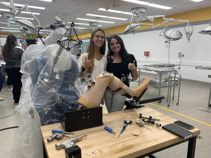 Two women in lab holding a prosthetic device